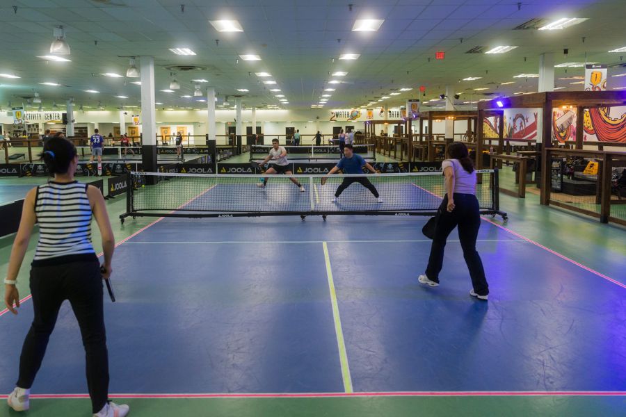 Four players playing pickleball on a blue court at Kraken Kourts & Skates in DC