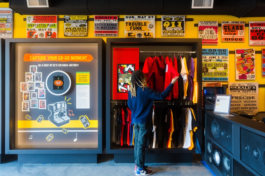 A visitor browses colorful merchandise inside the Go-Go Museum, surrounded by historic go-go music posters.