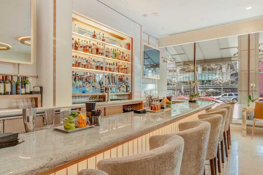 A sleek, modern bar with plush seating and a well-stocked liquor display.