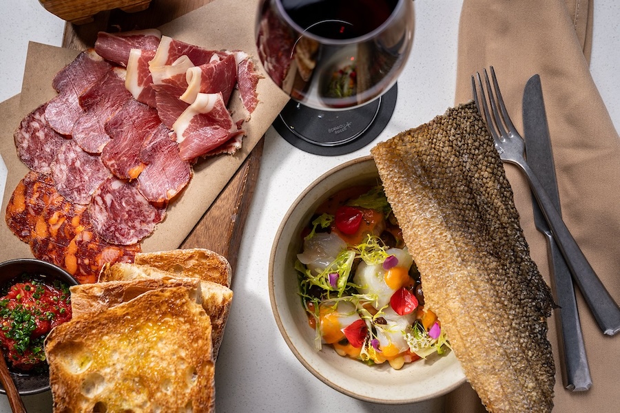 A spread of charcuterie, seafood and wine arranged elegantly on a restaurant table.