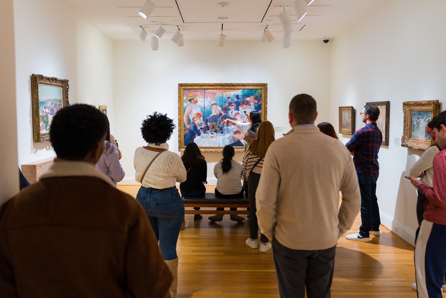 A group of visitors listens to a guide discuss a famous Impressionist painting at The Phillips Collection in Washington, DC.