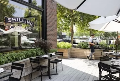 outdoor patio with umbrellas and dining setup, surrounded by herb gardens